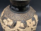 a black and white vase with a design on it
