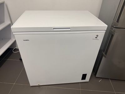 a small white refrigerator in the corner of a kitchen