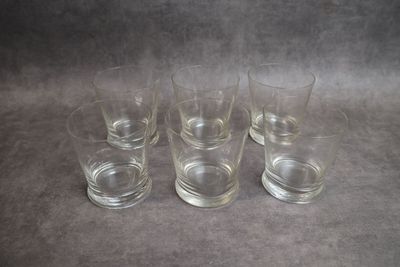 quatre verres à shot sont alignés sur une surface grise