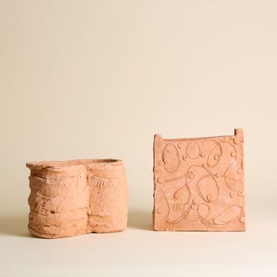 deux pièces de poterie posées sur une surface blanche