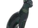 une statue de chat noir posée sur une surface blanche