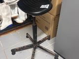 a black chair that is sitting in front of a refrigerator