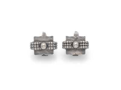 une paire de boucles d'oreilles en diamant et en argent sur fond blanc