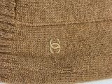 brown knitted sweater with a gold logo on the front