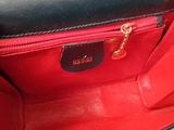 the inside of a black and red purse with a gold chain