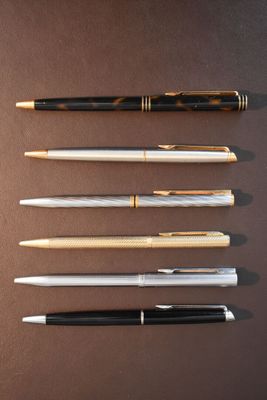 four different types of pens lined up on top of a table