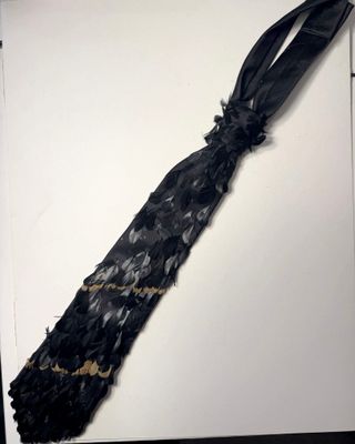 une cravate noire sur un fond blanc, ornée d'un ruban noir