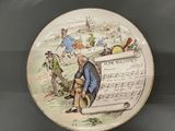 a plate with a picture of a man holding a sheet of music