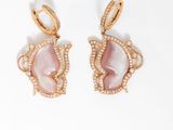 Les boucles d'oreilles en nacre rose sont ornées de diamants
