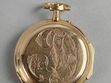 an image of a gold pocket watch with a picture of a woman on it