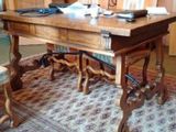 a large wooden table with chairs and a rug on the floor