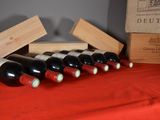 several bottles of wine are lined up on a red table cloth
