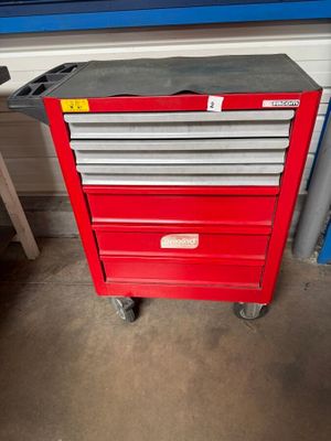 a close up of a red tool box on wheels in a garage