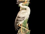 an image of a statue of a bird sitting on top of a plant