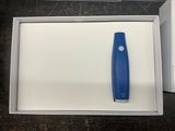 un objet bleu et blanc dans une boîte posée sur une table