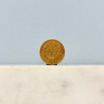 une pièce d'or posée sur une dalle de marbre