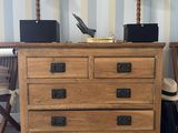 a wooden chest of drawers with a laptop on top of it
