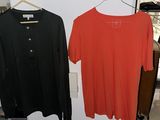 pair of black and orange shirts hanging on a rack in a clothing store