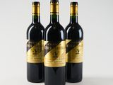three bottles of wine sitting on top of a white table