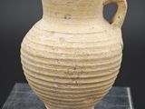 une image représentant un vase muni d'une anse, posé sur un socle