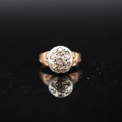 gros plan d'une bague en or et diamants sur une surface noire
