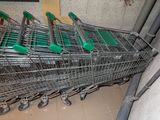 many shopping carts lined up in a row in a store