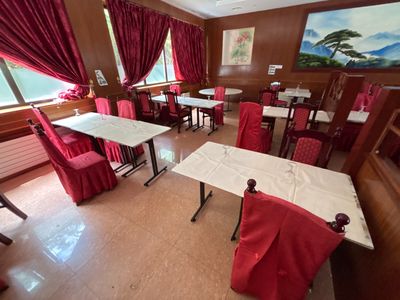 des tables et des chaises dans un restaurant, recouvertes de rideaux rouges