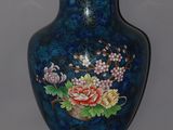 a blue vase with flowers on it sitting on a table
