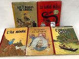quatre livres pour enfants sont alignés sur une surface blanche