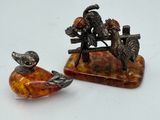 two figurines of birds sitting on a tree branch