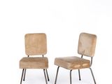 pair of mid - century chairs with upholstered backrests and metal legs