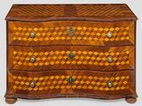 une commode en bois dont la façade est ornée d'un motif en damier