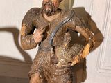 une statue représentant un homme tenant un chien dans ses bras