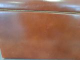 a brown leather suitcase sitting on a white table