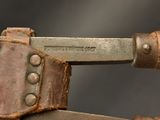 a close up of a knife on a piece of wood