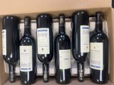 six bottles of wine are in a cardboard box on a table