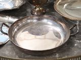 a table with silver plates and silver dishes on it