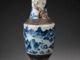 a blue and white vase with a mountain scene on it