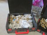 two black cases with gold and silver items in them