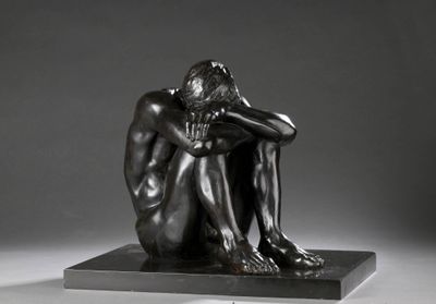 statue d'un homme assis sur un socle, la tête entre les mains