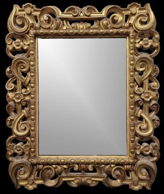un miroir au cadre doré ouvragé sur fond noir