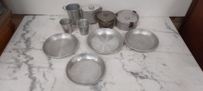 a lot of silver dishes and pans sitting on a counter