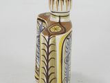 a small vase with a design on it on a white surface