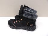 black boots with fur lined up on top of them on a white surface