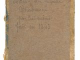 an old book with writing on it sitting on top of a table