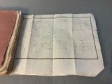 an old book sitting on top of a table next to a piece of paper