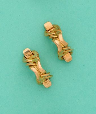 une paire de boucles d'oreilles à clip dorées sur fond turquoise