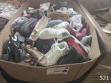 plusieurs paires de chaussures dans une boîte posée sur le sol