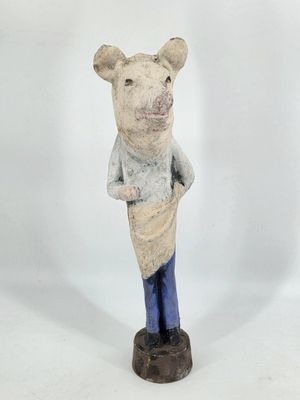 figurine of a pig in a sweater and jeans standing on a wooden base