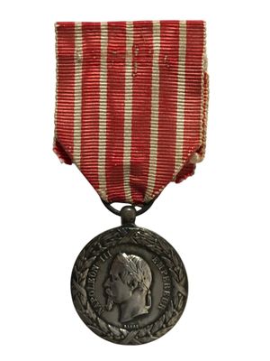 une vieille médaille entourée d'un ruban à rayures rouges et blanches